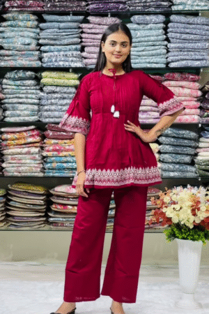 Women’s Red Embroidered Kurti Pant Set – White Threadwork Details with Boutique Shelf Backdrop